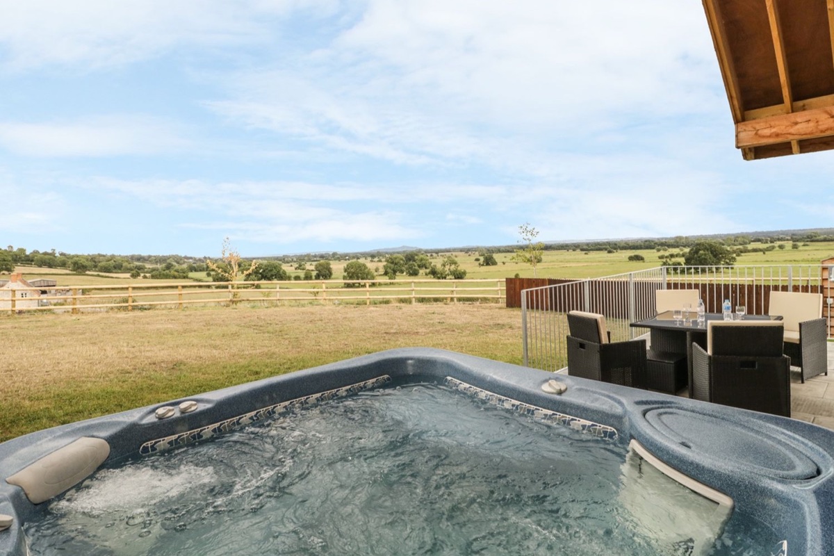 Swan Lodge Castle Farm hot tub facing fenced fields in Wedmore