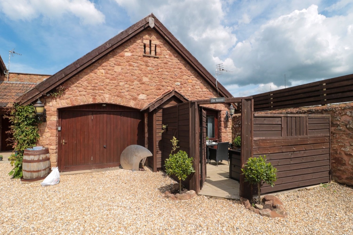 The Retreat stone exterior with garage door and entrance gate