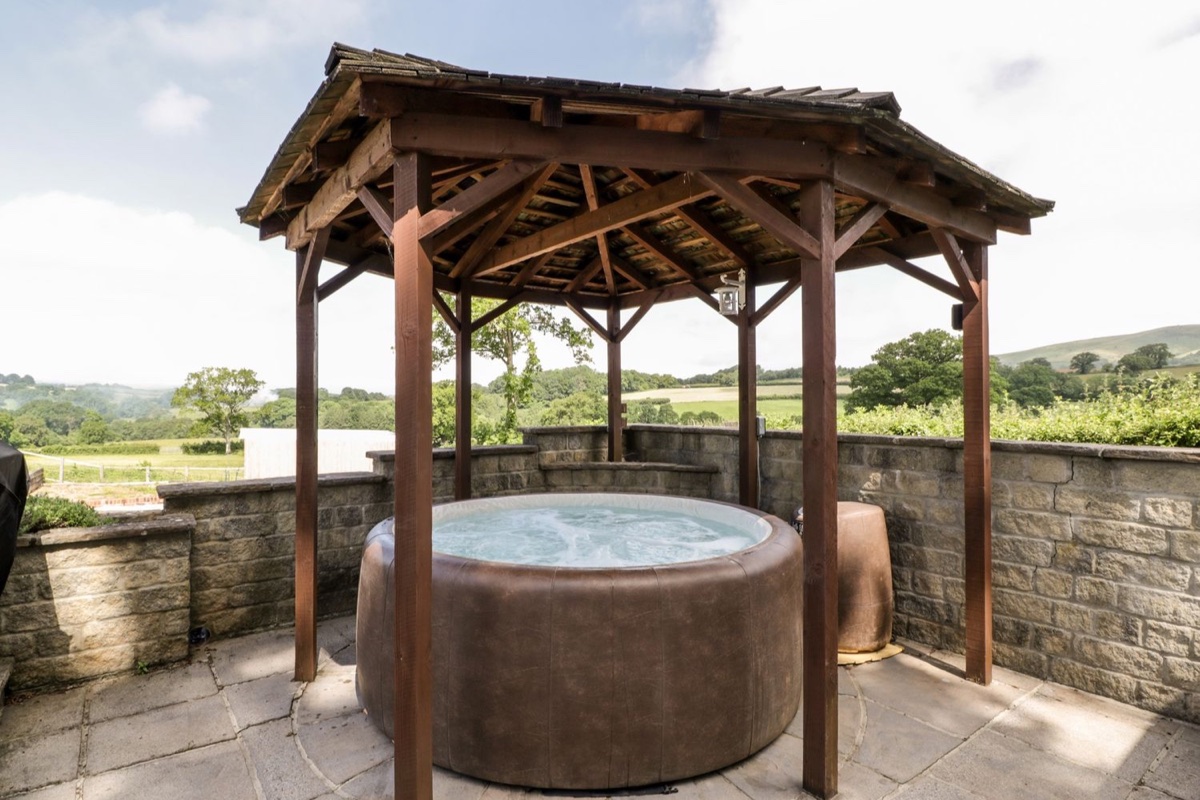 The Stables hot tub under a wooden gazebo in Crowcombe
